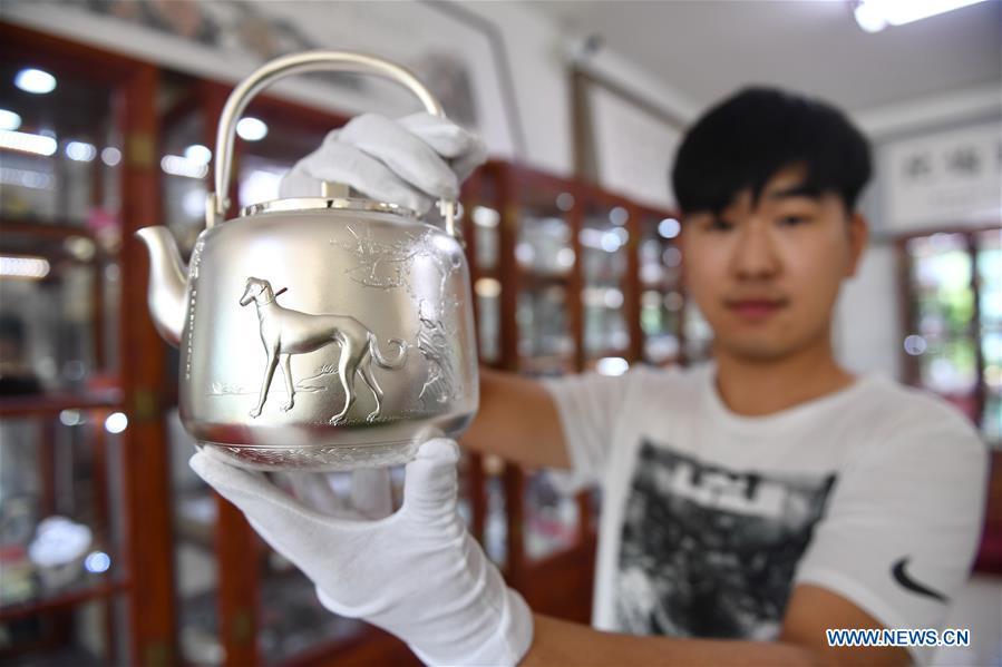 A worker displays a silverware at a workshop in Malanyu Township in Zunhua City, north China\'s Hebei Province, July 11, 2018. Gold and silver processing in Malanyu Township has a long history and the industry is expanding as craftsmen blend modern elements with traditional techniques in recent years. To date, there are more than 80 enterprises that provide over 2,000 jobs for local residents. (Xinhua/Mu Yu)