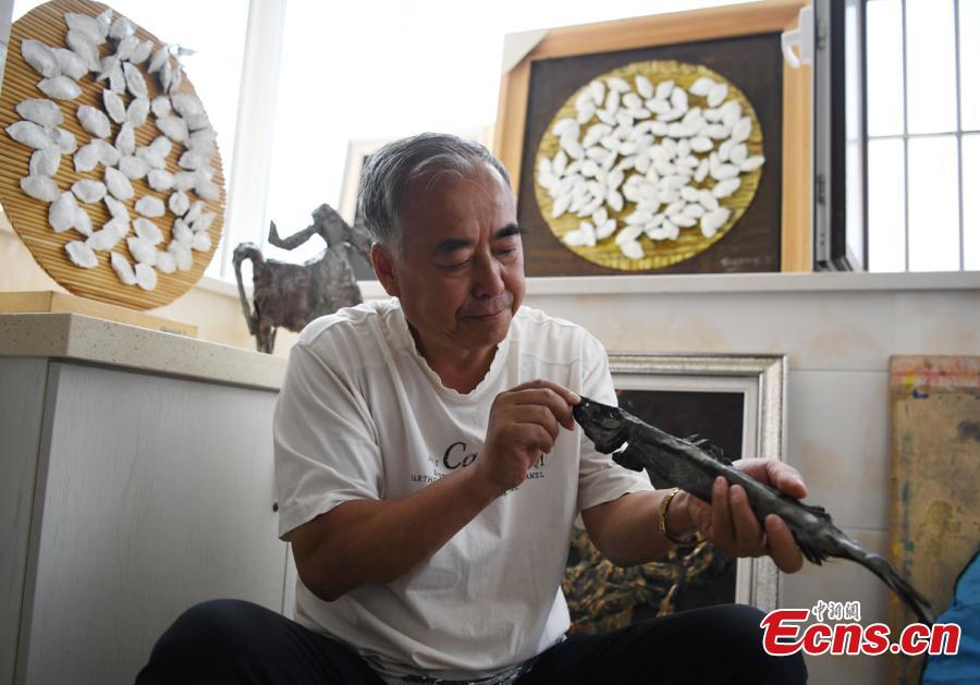 Sui Jincai, an art teacher, shows iron artworks in Changchun City, Jilin Province, July 11, 2018. Sui uses acrylic paints and iron materials to create vivid 3D creations. (Photo: China News Service/Zhang Yao)