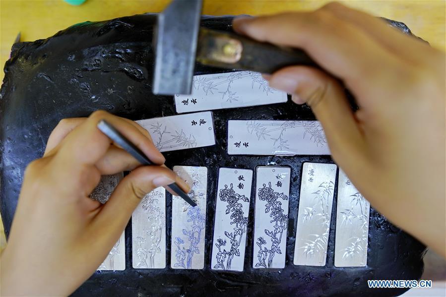 A worker carves a silverware at a workshop in Malanyu Township in Zunhua City, north China\'s Hebei Province, July 11, 2018. Gold and silver processing in Malanyu Township has a long history and the industry is expanding as craftsmen blend modern elements with traditional techniques in recent years. To date, there are more than 80 enterprises that provide over 2,000 jobs for local residents. (Xinhua/Mu Yu)