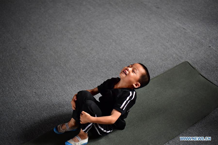 A trainee does a somersault excercise at an acrobatics school in Dongbeizhuang Village of Puyang, central China\'s Henan Province, July 11, 2018. In Dongbeizhuang Village, an acrobatics school enrols some 40 trainees aged between five and 15 who are faced with financial difficulties. The school offers both skills trainings and academic lessons but charges no tuition fees, preparing the trainees to join larger troupes with greater opportunities. (Xinhua/Feng Dapeng)