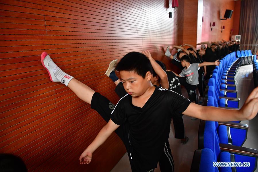 Trainees do warm-up excercises at an acrobatics school in Dongbeizhuang Village of Puyang, central China\'s Henan Province, July 11, 2018. In Dongbeizhuang Village, an acrobatics school enrols some 40 trainees aged between five and 15 who are faced with financial difficulties. The school offers both skills trainings and academic lessons but charges no tuition fees, preparing the trainees to join larger troupes with greater opportunities. (Xinhua/Feng Dapeng)