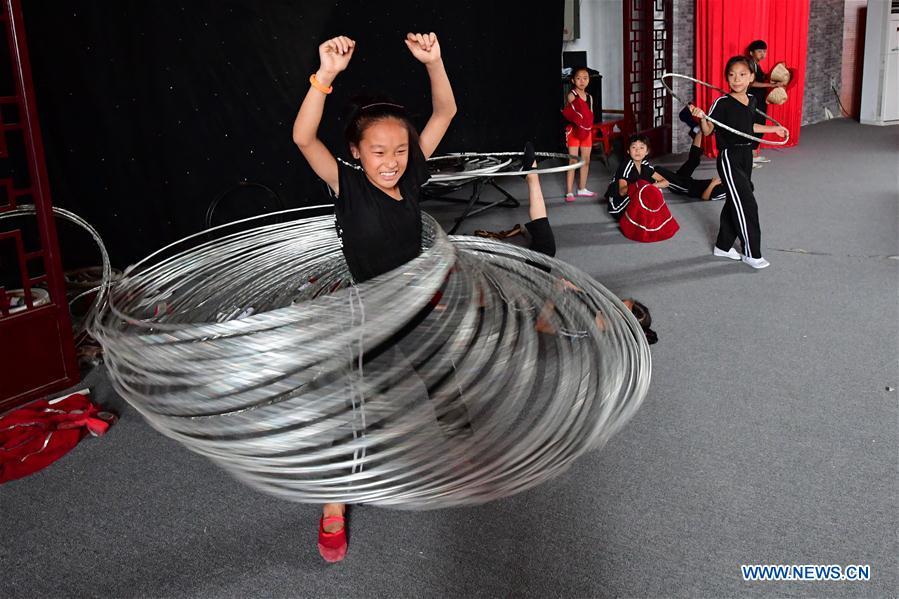 Trainees practice at an acrobatics school in Dongbeizhuang Village of Puyang, central China\'s Henan Province, July 11, 2018. In Dongbeizhuang Village, an acrobatics school enrols some 40 trainees aged between five and 15 who are faced with financial difficulties. The school offers both skills trainings and academic lessons but charges no tuition fees, preparing the trainees to join larger troupes with greater opportunities. (Xinhua/Feng Dapeng)