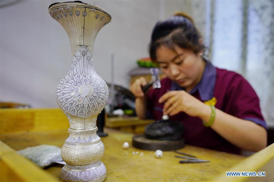 A worker makes a silverware at a workshop in Malanyu Township in Zunhua City, north China\'s Hebei Province, July 11, 2018. Gold and silver processing in Malanyu Township has a long history and the industry is expanding as craftsmen blend modern elements with traditional techniques in recent years. To date, there are more than 80 enterprises that provide over 2,000 jobs for local residents. (Xinhua/Mu Yu)