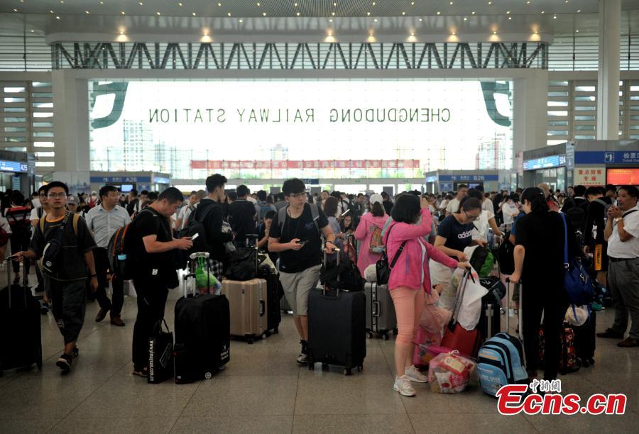 Passengers are stranded at a railway station in Chengdu City, Sichuan Province, July 11, 2018 following the cancellation of dozens of trains due to continuous heavy rain. (Photo: China News Service/Liu Zhongjun)