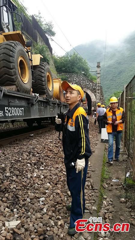 Rescuers work to clean up a landslide that cut off the Baoji-Chengdu railway line in Lueyang County, Northwest China’s Gansu Province, July 13, 2018 after continuous heavy rain. Local railway authorities have mobilized thousands of people to resume train operations. (Photo provided to China News Service)