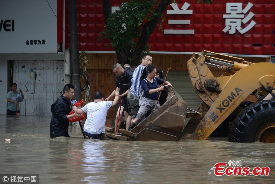 A bulldozer transports people on a flooded street in Jintang County, Southwest China’s Sichuan Province, July 12, 2018, after heavy rain. (Photo/VCG)