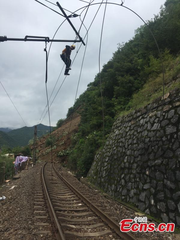 Rescuers work to clean up a landslide that cut off the Baoji-Chengdu railway line in Lueyang County, Northwest China’s Gansu Province, July 13, 2018 after continuous heavy rain. Local railway authorities have mobilized thousands of people to resume train operations. (Photo provided to China News Service)