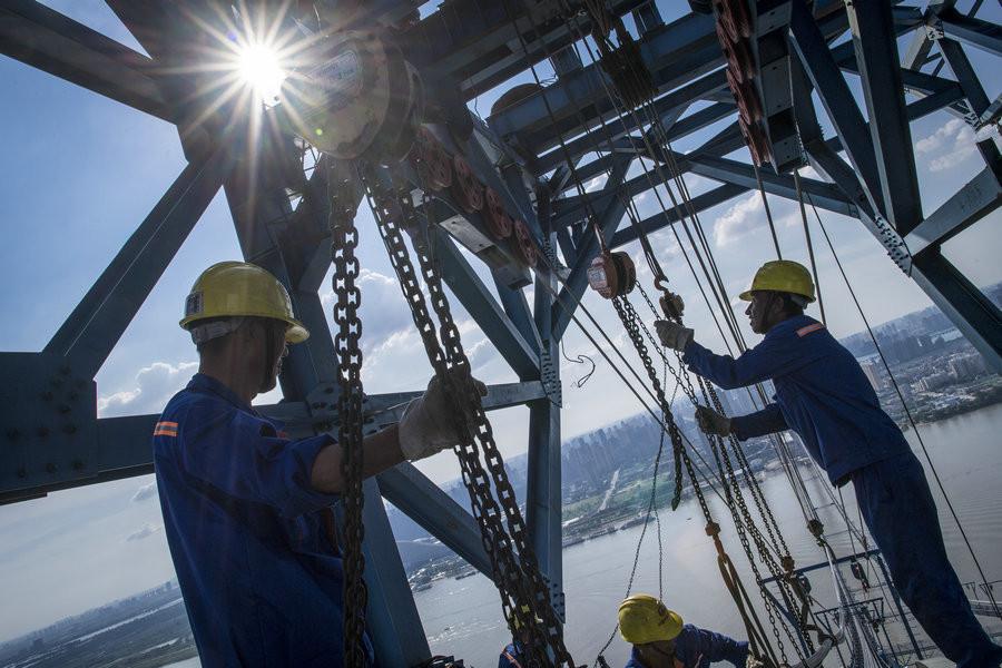 Workers set up the main cable. (Photo/Xinhua)

The construction site of the Wuhan Yangsi Port Yangtze River Bridge is 200 meters high. And this is where nearly 80 workers from the China Railway Major Bridge Engineering Group work day and night. They shuttle on the \