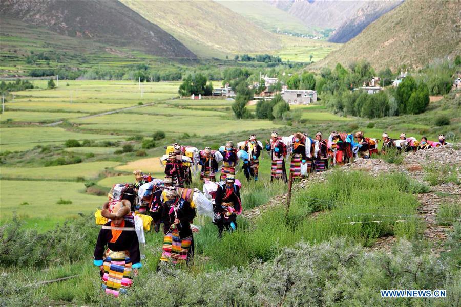 People of Tibetan ethnic group take part in a ceremony to pray for harvest during the annual Ongkor Festival in Qangkyim Village of Shannan City, southwest China\'s Tibet Autonomous Region, July 14, 2018. The Ongkor Festival, or Bumper Harvest Festival, which has a history of more than 1,500 years, is celebrated annually by local farmers praying for good harvests of crops. (Xinhua/Lhunzhub Cering)