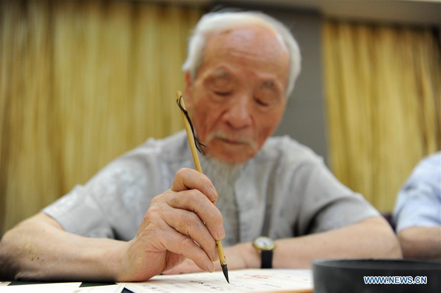 Wu Yaohui, a retired teacher from Shaanxi Normal University, writes an admission letter with Chinese writing brush in Xi\'an, northwest China\'s Shaanxi Province, July 16, 2018. Around 4,500 admission letters written by representatives of alumni and retired teachers from Shaanxi Normal University will be delivered to freshmen. The hand-written admission letter has become a feature of Shaanxi Normal University since 2007. (Xinhua/Zhang Bowen)