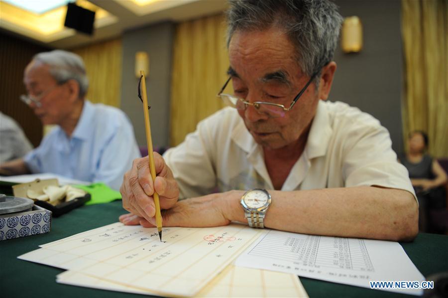 Yang Mingtang, a retired teacher from Shaanxi Normal University, writes an admission letter with Chinese writing brush in Xi\'an, northwest China\'s Shaanxi Province, July 16, 2018. Around 4,500 admission letters written by representatives of alumni and retired teachers from Shaanxi Normal University will be delivered to freshmen. The hand-written admission letter has become a feature of Shaanxi Normal University since 2007. (Xinhua/Zhang Bowen)