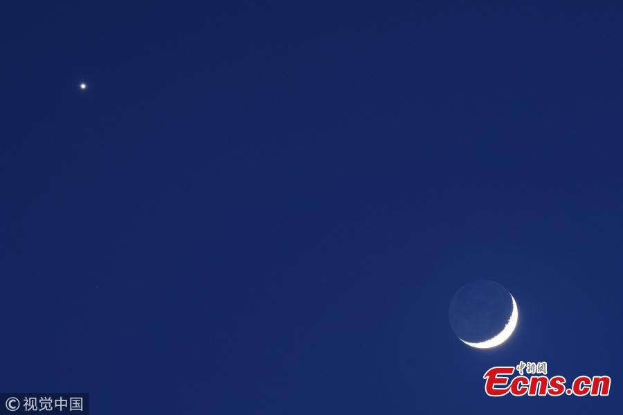 Venus (above) appears in the night sky near a crescent moon on July 15, 2018 in Bogota, Colombia. The conjunction of the planet Venus was seen next to the crescent moon and the regulus star from sunset to sunrise. (Photo/VCG)