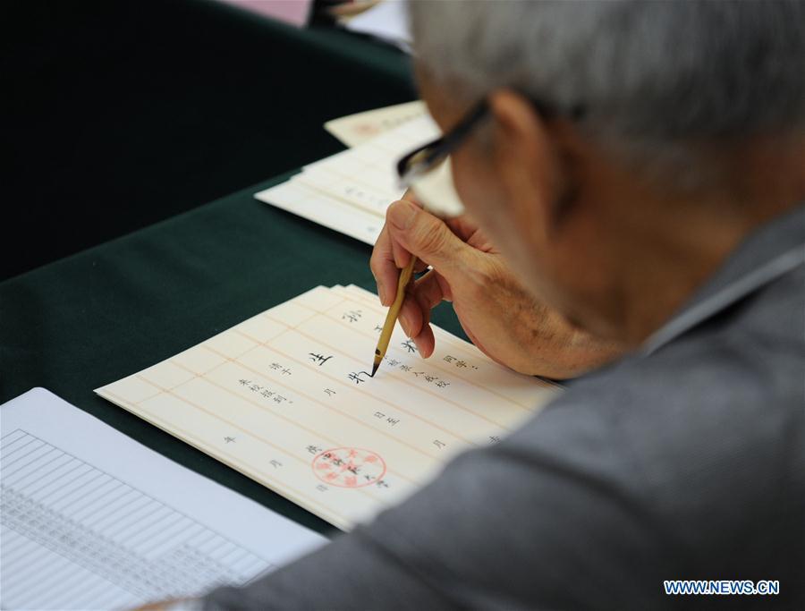 Qu Peiheng, a retired teacher from Shaanxi Normal University, writes an admission letter with Chinese writing brush in Xi\'an, northwest China\'s Shaanxi Province, July 16, 2018. Around 4,500 admission letters written by representatives of alumni and retired teachers from Shaanxi Normal University will be delivered to freshmen. The hand-written admission letter has become a feature of Shaanxi Normal University since 2007. (Xinhua/Zhang Bowen)
