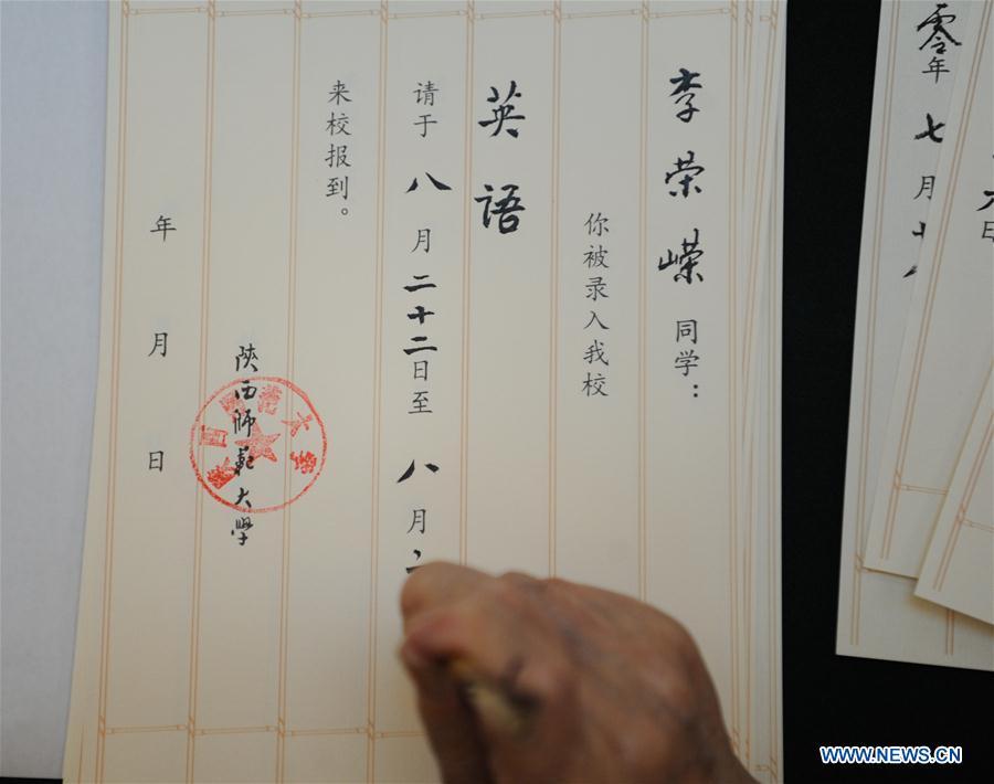Qu Peiheng, a retired teacher from Shaanxi Normal University, writes an admission letter with Chinese writing brush in Xi\'an, northwest China\'s Shaanxi Province, July 16, 2018. Around 4,500 admission letters written by representatives of alumni and retired teachers from Shaanxi Normal University will be delivered to freshmen. The hand-written admission letter has become a feature of Shaanxi Normal University since 2007. (Xinhua/Zhang Bowen)