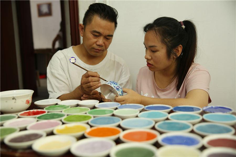Wang demonstrates the glazing skill on a silver ware in his factory, Danzhai county, Southwest China\'s Guizhou Province, July 12, 2018. (Photo//Asianewsphoto)