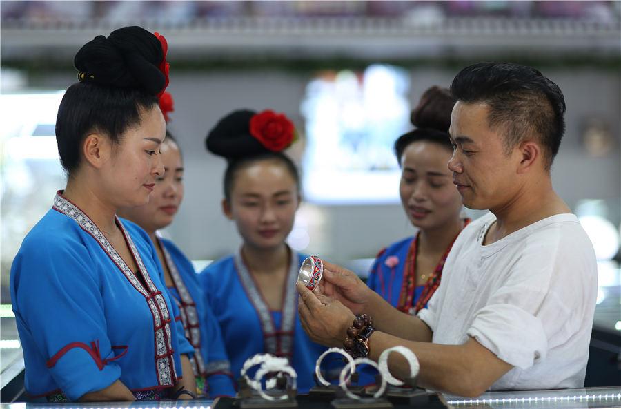 Wang trains the saleswomen at his store, July 12, 2018. (Photo//Asianewsphoto)
Wang Guochun, coming from a long line of silversmiths, is now a local intangible heritage successor creating a better life for his family and his fellow villagers.
He left his hometown when he was a teenager to work for a jewelry factory and support his family. There, Wang was exposed to modern jewelry design and business management which paved the way for his own silverware start-up in 2010.
Focusing on handmade silverware with an exotic ethnic style, he has obtained 8 patents on jewelry making techniques and 50 patents on jewelry designs. The former workshop now has grown into a company with 1 million yuan ($150,000) sales every month.
Wang combines online and store marketing together, which promotes his products to an international clientele.
Now, he wants to lift more villagers in Southwest China\'s Guizhou Province out of poverty. He has created 84 jobs for local residents. Free silversmith training courses are open to over 500 low-income individuals.
\