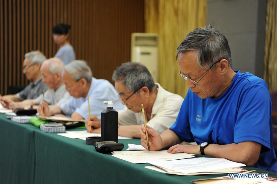 Ma Fantao (1st R), a retired teacher from Shaanxi Normal University, writes an admission letter with Chinese writing brush in Xi\'an, northwest China\'s Shaanxi Province, July 16, 2018. Around 4,500 admission letters written by representatives of alumni and retired teachers from Shaanxi Normal University will be delivered to freshmen. The hand-written admission letter has become a feature of Shaanxi Normal University since 2007. (Xinhua/Zhang Bowen)