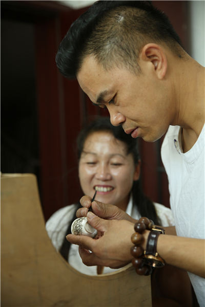 Wang demonstrates the splicing skill on a silver ware in his factory, Danzhai county, Southwest China\'s Guizhou Province, July 12, 2018. (Photo//Asianewsphoto)