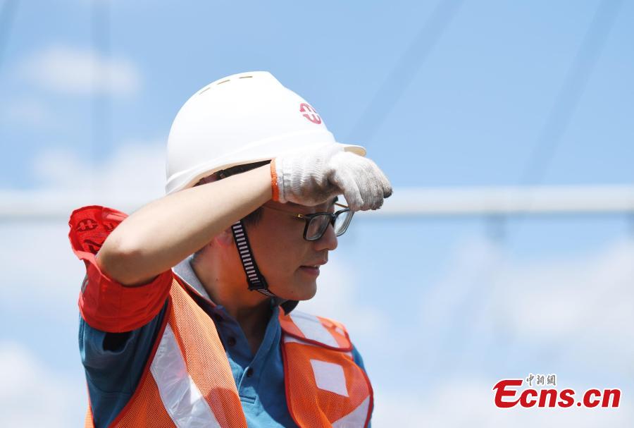A signal inspection technician works on a railway track as temperatures reach a high of 36 degrees centigrade in Hangzhou City, East China’s Zhejiang Province, July 16, 2018. (Photo: China News Service/Wang Gang)