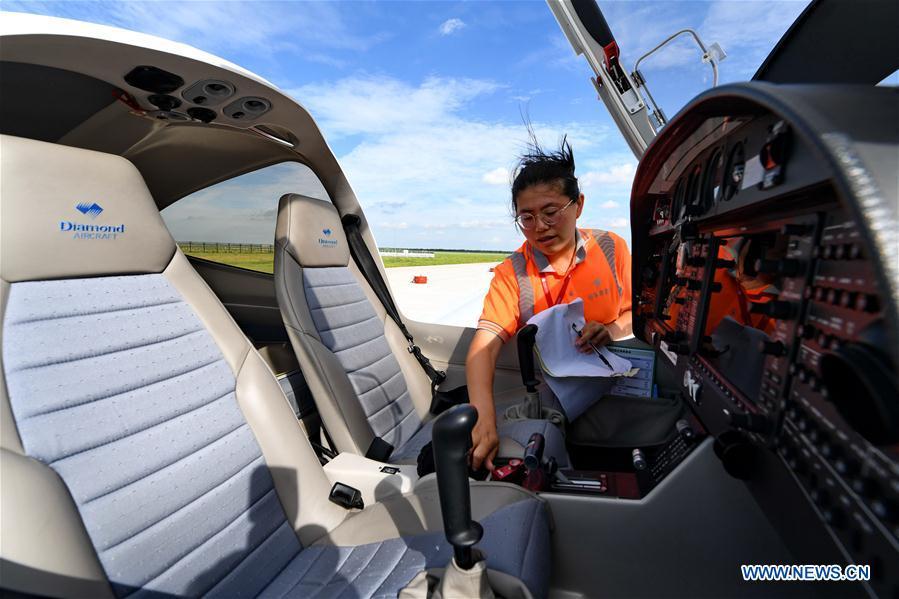Deng Yun checks an aircraft at the Chagan Lake airport in Songyuan, northeast China\'s Jilin Province, July 17, 2018. Deng was born in 1991. She is an aircraft maintenance technician of an aviation academy in Jilin. The young female engineer and other nine colleagues are in charge of training plane maintenance at the airport. To ensure the flight safety, they need to check more than 100 items before a plane takes off. (Xinhua/Zhang Nan)