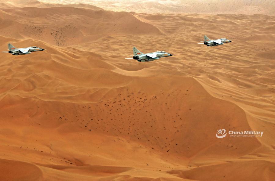 Three fighter jets conduct a fly-by over the desert during the \