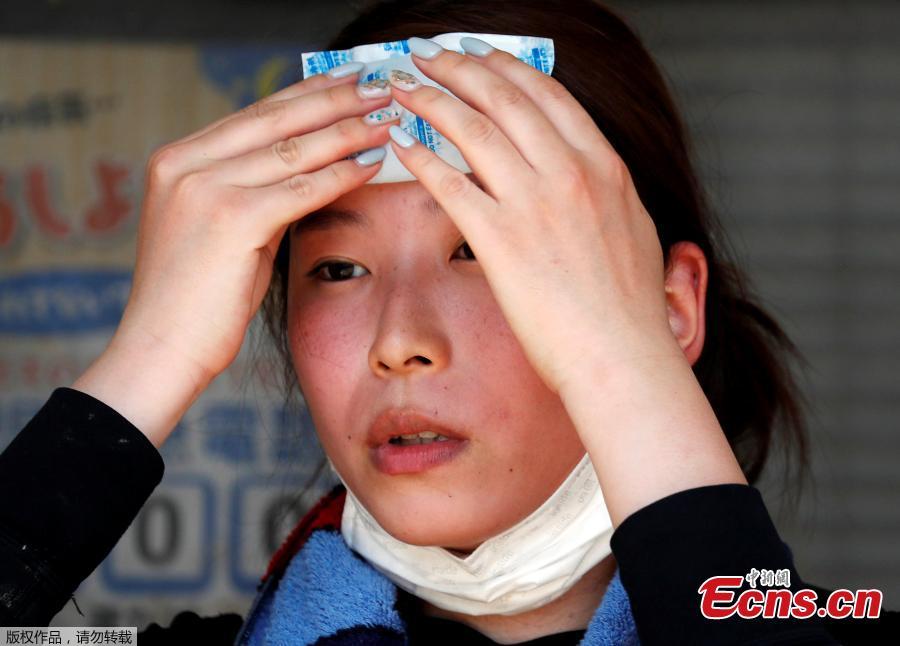 A volunteer, for recovery work, uses a pack of refrigerant to a cool down as she takes a break in a heat wave at a flood affected area in Kurashiki, Okayama Prefecture, Japan, July 14, 2018. (Photo/Agencies)
