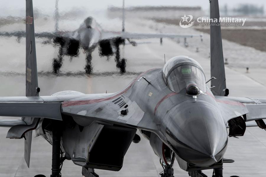 Two fighter jets taxi on the runway in formation before takeoff for a combat sortie during the \