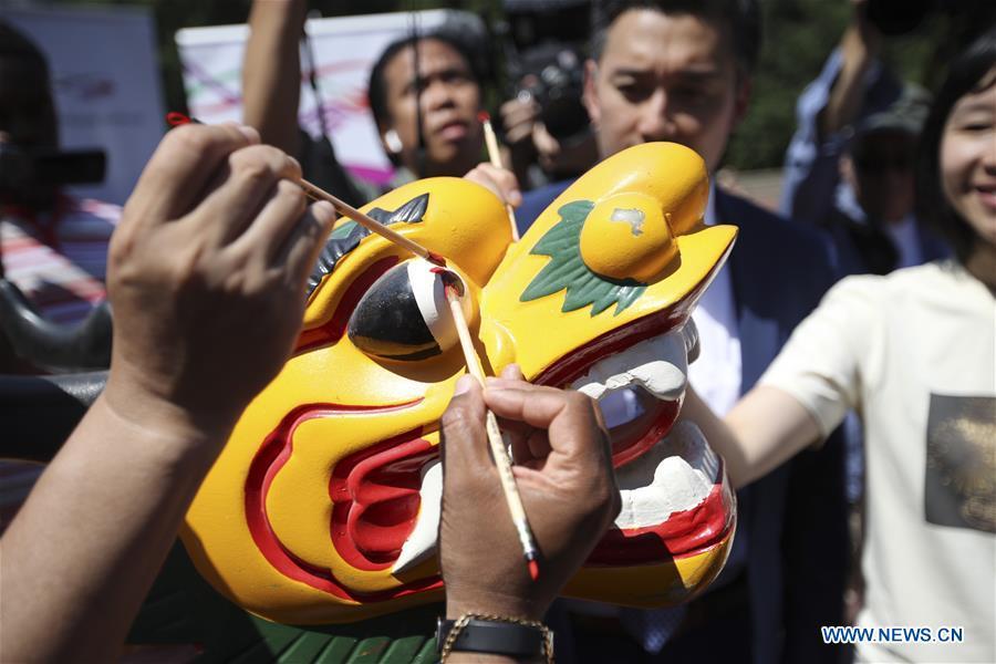 Invited guests paint red dots on the eyes of a dragon boat figure head during a traditional dragon boat awakening ceremony for the 28th annual Hong Kong Dragon Boat Festival in New York, the United States, on July 18, 2018. The ceremony marked the start of the training period for over 200 teams competing in this year\'s dragon boat races on Aug. 11 and Aug. 12 in New York. (Xinhua/Wang Ying)