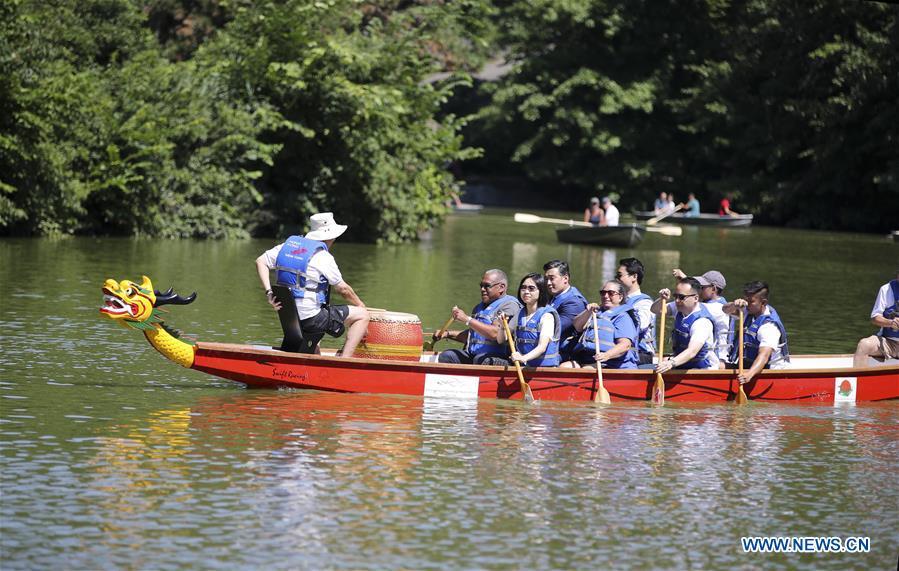 Invited guests row a dragon boat prior to a traditional dragon boat awakening ceremony for the 28th annual Hong Kong Dragon Boat Festival in New York, the United States, on July 18, 2018. The ceremony marked the start of the training period for over 200 teams competing in this year\'s dragon boat races on Aug. 11 and Aug. 12 in New York. (Xinhua/Wang Ying)