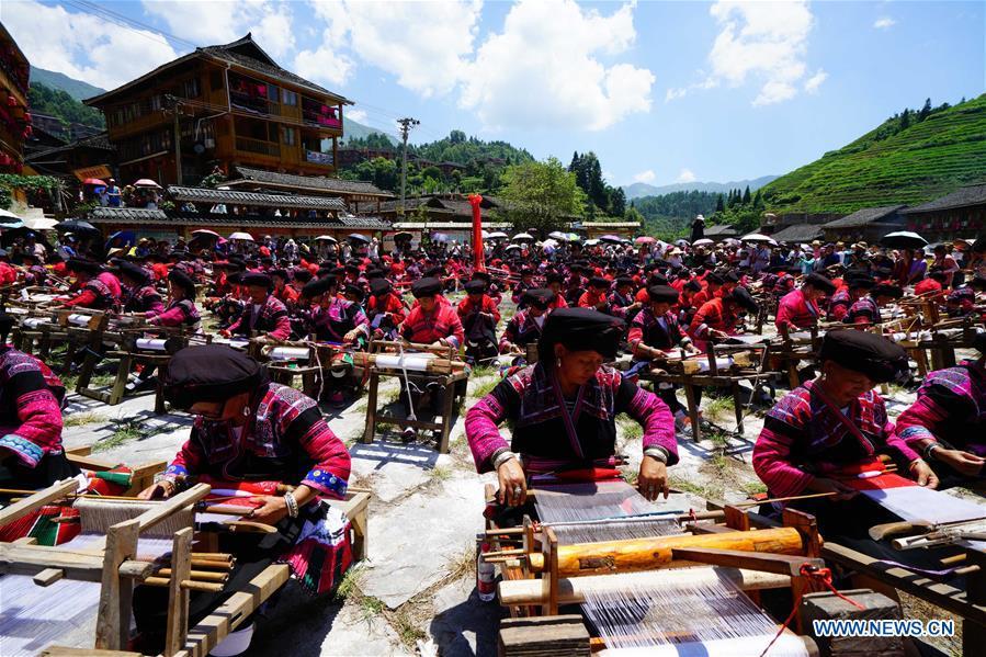 Women of Yao ethnic group present the skills of making folk costumes in Longji Township of Guilin, south China\'s Guangxi Zhuang Autonomous Region, July 18, 2018. Local people of Yao ethnic group on Wednesday celebrated annual \
