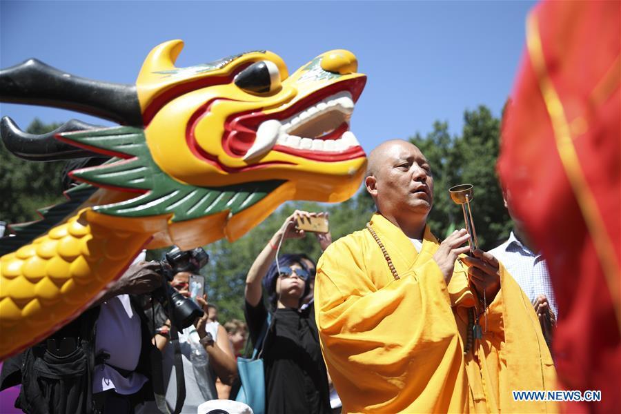 A monk gives blessings during a traditional dragon boat awakening ceremony for the 28th annual Hong Kong Dragon Boat Festival in New York, the United States, on July 18, 2018. The ceremony marked the start of the training period for over 200 teams competing in this year\'s dragon boat races on Aug. 11 and Aug. 12 in New York. (Xinhua/Wang Ying)