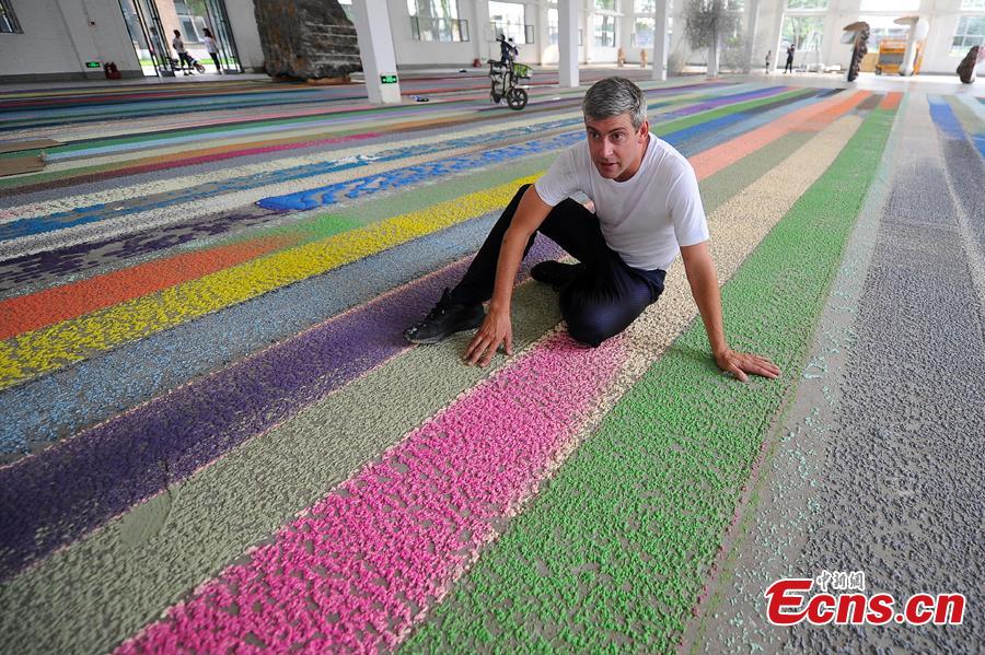 Swiss visual artist Raphael Hefti poses with his creation during an international sculpture festival in Pingyao County, North China’s Shanxi Province. More than 40 artists brought their sculpture works to the festival in the ancient town.(Photo: China News Service/Wei Liang)