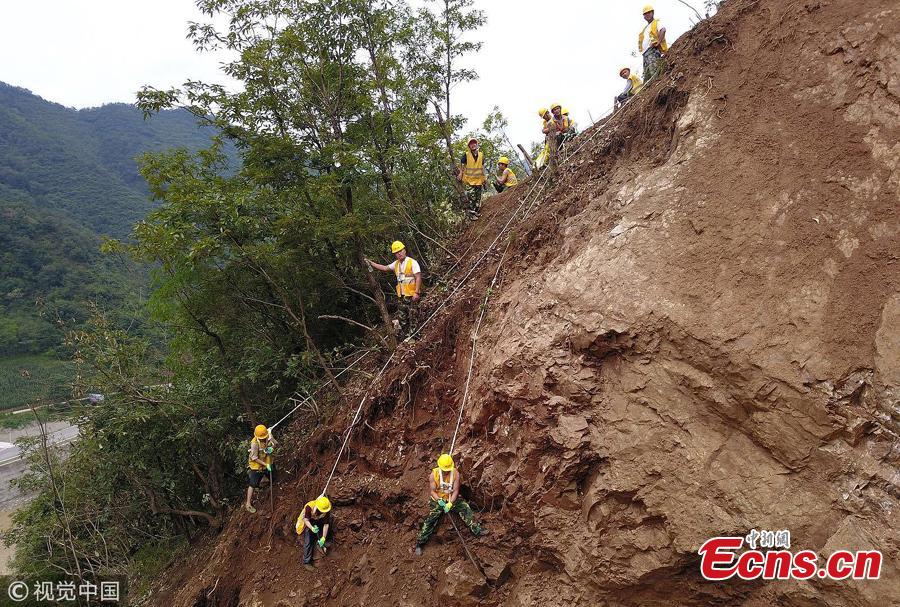 Rescuers clean up a landslide that affected the Baoji-Chengdu Railway after heavy rain in Lueyang County, Northwest China’s Gansu Province, July 18, 2018. More than 1,000 people have worked 24 hours to clean up the landslide and resume operations as soon as possible. (Photo/VCG)