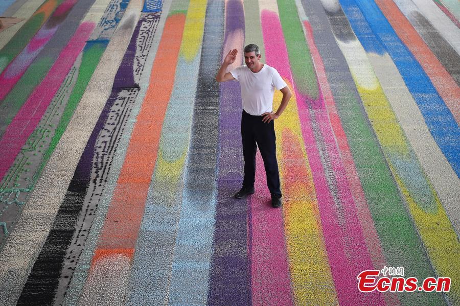 Swiss visual artist Raphael Hefti poses with his creation during an international sculpture festival in Pingyao County, North China’s Shanxi Province. More than 40 artists brought their sculpture works to the festival in the ancient town.(Photo: China News Service/Wei Liang)