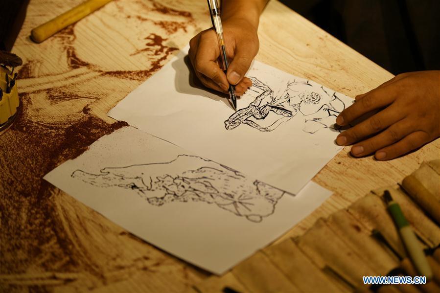 Craftsman Guo Dong designs wood carvings at a studio in Shijiazhuang, capital of north China\'s Hebei Province, July 20, 2018. The \