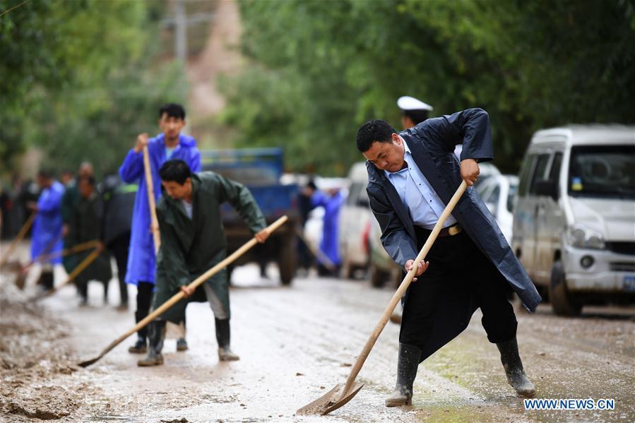 People clear the mud at flood-hit Chenhe Village of Dongxiang Autonomous County in Linxia Hui Autonomous Prefecture, northwest China\'s Gansu Province, July 20, 2018. About 1.08 million people in Gansu Province were affected by rain-triggered floods, with 12 deaths, four people missing and 27,000 people evacuated. (Xinhua/Chen Bin)