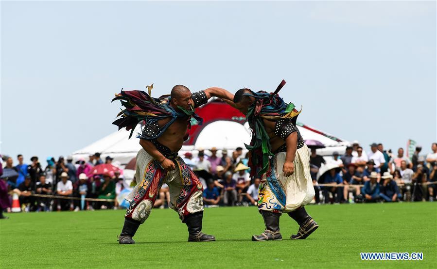 Herdsmen take part in a wrestling celebrating Baima Festival held in West Ujimqin Banner, north China\'s Inner Mongolia Autonomous Region, July 22, 2018. The two-day event is a mass traditional Mongolian festival mainly filled with sports events. (Xinhua/Liu Lei)