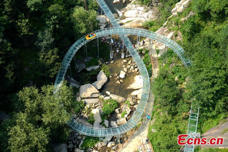 An aerial view of a waterslide over the Xiangma River in Lushan County, Central China’s Henan Province, July 23, 2018. The 2.3-kilometer-long waterslide around a mountain slope and cliff has a vertical drop of 100 meters, earning it the title of the longest and most challenging waterslide in central China. The thrilling project opened on Monday. (Photo: China News Service/Dong Fei)