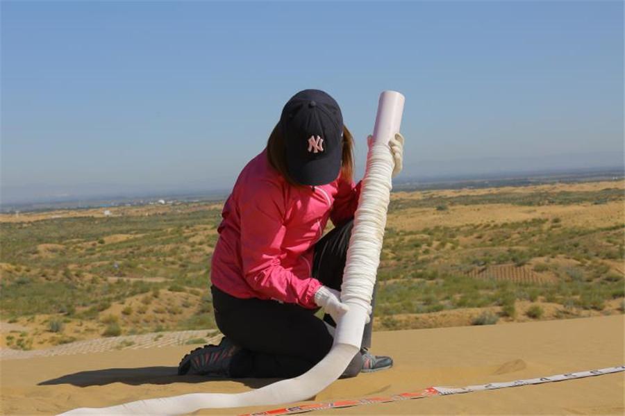 The use of degradable material by sand barrier technology is helping transform hundreds of acres of Inner Mongolia\'s Kubuqi Desert into green landscape in an environment-friendly way. (Photo provided to chinadaily.com.cn)