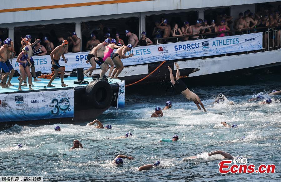 Athletes begin their race from Asia to Europe in the Bosphorus strait during the Bosporus Cross-Continental Swimming Race in Istanbul, July 22, 2018. Over 2,000 open-water competitors plunged into the water from a ferry docked on the city\'s Asian side and swam for about 6.5km in the cross-continental event. (Photo/Agencies)