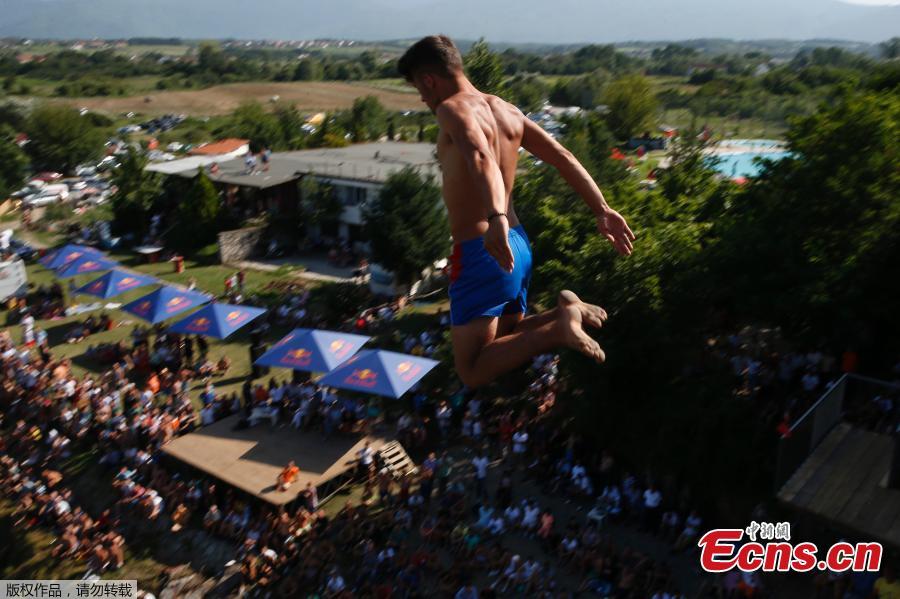People look at a man as he jumps from the 22 meters high bridge \'Ura e Shenjte\' during the annual traditional High Diving competition near the town of Gjakova on July 22, 2018. (Photo/Agencies)