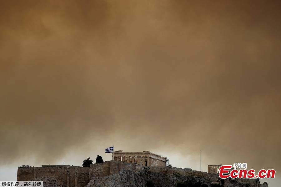 Smoke from a wildfire burning outside Athens is seen over the Parthenon temple atop the Acropolis hill in Athens, Greece, July 23, 2018. At least 20 people died and more than 100 were injured on Monday as a wildfire swept through a small resort town in eastern Greece with many victims trapped by flames as they fled. (Photo/Agencies)