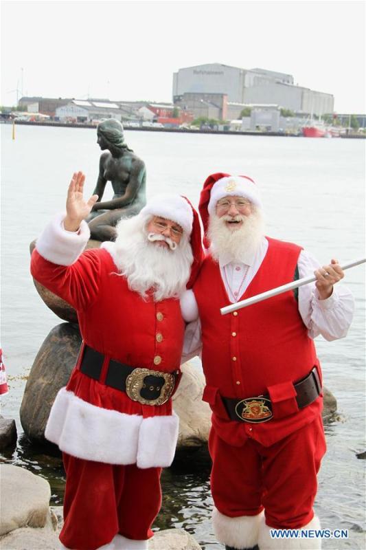 People dressed as Santa Claus pose for photos near the Little Mermaid statue in Copenhagen, capital of Denmark, on July 23, 2018. The 2018 World Santa Claus Congress kicked off at Bakken amusement park, north of Copenhagen, on Monday. Some 100 Santa Claus from around the globe gathered here in the Danish capital city during the four-day event. (Xinhua/Wu Bo)