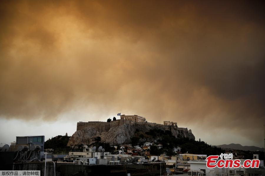 Smoke from a wildfire burning outside Athens is seen over the Parthenon temple atop the Acropolis hill in Athens, Greece, July 23, 2018. At least 20 people died and more than 100 were injured on Monday as a wildfire swept through a small resort town in eastern Greece with many victims trapped by flames as they fled. (Photo/Agencies)