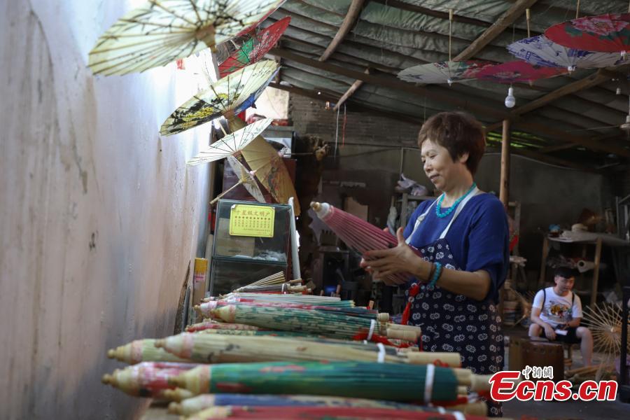 Li Zhenxia, a master at creating oil-paper umbrellas, works in a studio in Datong Ancient Town in Chishui City, Southwest China’s Guizhou Province, July 24, 2018. In 2017, Li sold about 10,000 oil-paper umbrellas and earned an income of one million yuan. The town has made efforts to creatively develop traditional handicrafts including bamboo weaving and oil-paper umbrella, which help lift locals out of poverty. (Photo: China News Service/Qu Honglun)