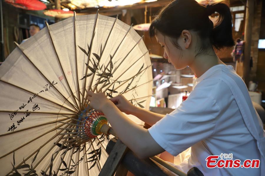 A middle school pupil learns about making an oil-paper umbrella in Datong Ancient Town in Chishui City, Southwest China’s Guizhou Province, July 24, 2018. The town has made efforts to creatively develop traditional handicrafts including bamboo weaving and oil-paper umbrella, which help lift locals out of poverty. (Photo: China News Service/Qu Honglun)