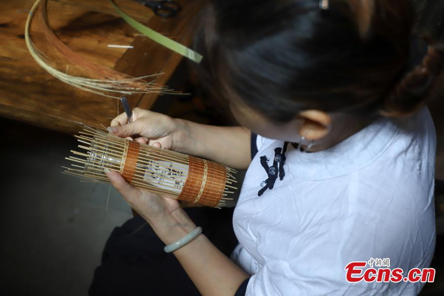 An apprentice learns about bamboo weaving in Datong Ancient Town in Chishui City, Southwest China’s Guizhou Province, July 24, 2018. The town has made efforts to creatively develop traditional handicrafts including bamboo weaving and oil-paper umbrella, which help lift locals out of poverty. (Photo: China News Service/Qu Honglun)