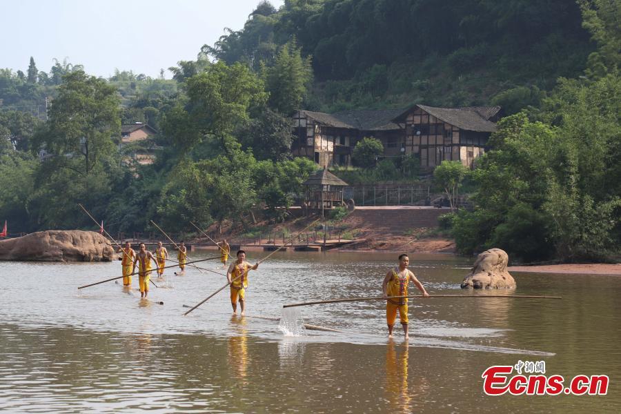 Performers show the single-bamboo pole drifting on water, an intangible cultural heritage, in Datong Ancient Town in Chishui City, Southwest China’s Guizhou Province, July 24, 2018. The town has made efforts to creatively develop traditional handicrafts including bamboo weaving and oil-paper umbrella, which help lift locals out of poverty. (Photo: China News Service/Qu Honglun)