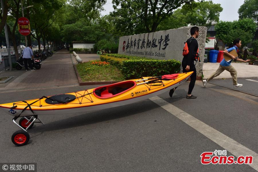 Sports teacher Sun Hua pulls a kayak to a middle school in Jiaxing City, East China’s Zhejiang Province. It usually takes him 25 minutes to complete his three-kilometer journey by water. (Photo/VCG)