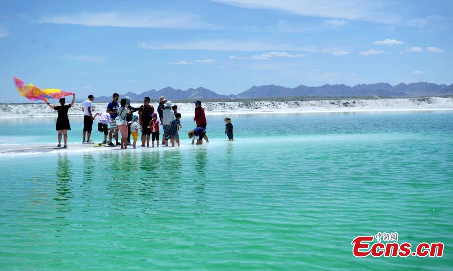 Da Qaidam salt lake in Haixi Mongol and Tibetan Autonomous Prefecture, Qinghai Province, July 25, 2018. The salt lake covering six square kilometers was formed by many years of mining, leaving a high concentration of salt called brine. It was named Emerald Lake because of its different and beautiful colors against the blue sky and snow-covered mountains. (Photo: China News Service/Liu Zhongjun)